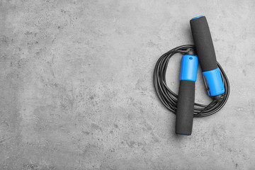 Jump rope and space for text on grey background, top view