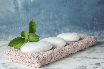 Beautiful composition with spa stones and towel on table
