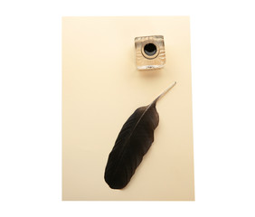 Feather pen, inkwell and sheet of paper on white background, top view. Space for text