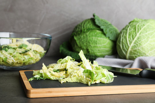 Cutting board with chopped savoy cabbage on table