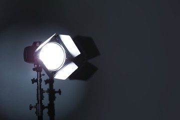 Professional photo studio lighting equipment on dark background. Space for text