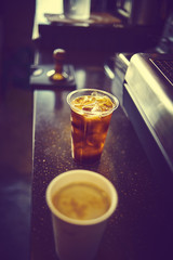 Take away plastic cup of iced black coffee