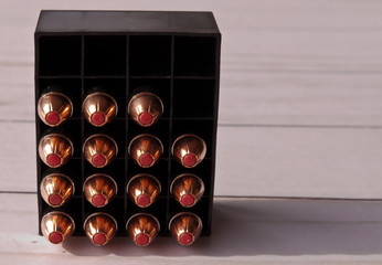 A black box of 44spl hollow point bullets showing 15 of them and 5 empty slots on a wooden...