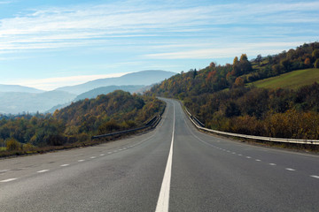 Landscape with asphalt road leading to mountains