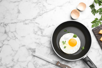 Pan with fried sunny side up egg served on table, flat lay with space for text
