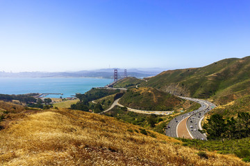 Aerial view of Freeway 101 going through golden and green hills in Marin County; Golden Gate Bridge...