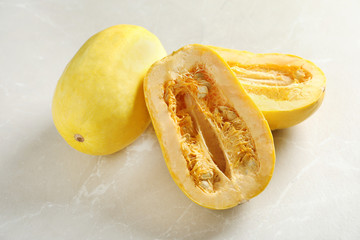 Whole and cut spaghetti squash on gray table