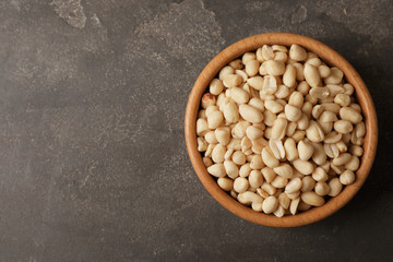 Shelled peanuts in bowl and space for text on table, top view