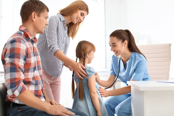 Obraz premium Children's doctor examining little girl near parents in hospital
