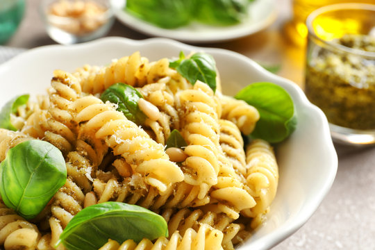 Plate of delicious basil pesto pasta on table, closeup