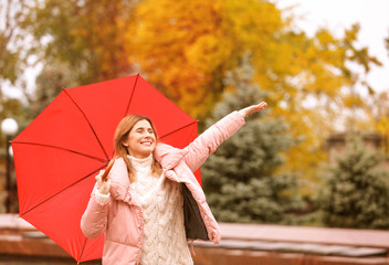 Woman with umbrella in autumn park on rainy day