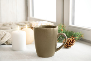 Fototapeta na wymiar Composition with cup of hot winter drink near window. Cozy season