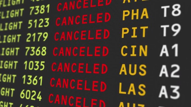 A close up view of an airport's travel information board with flights being cancelled.  	