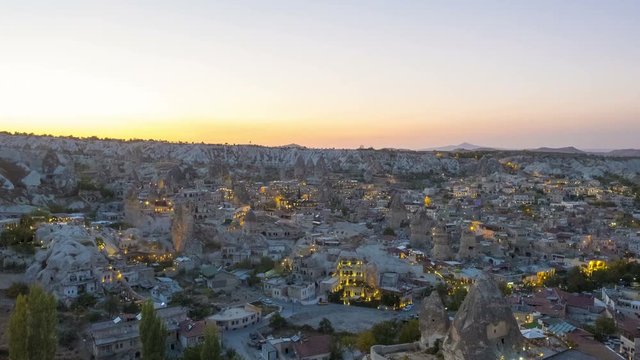 Zoom out day to night time lapse overlooking Goreme town hotels and restaurants slowly transitioning to city lights in Cappadocia, Turkey. 4k at 24fps