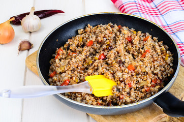 Buckwheat porridge with vegetables in pan