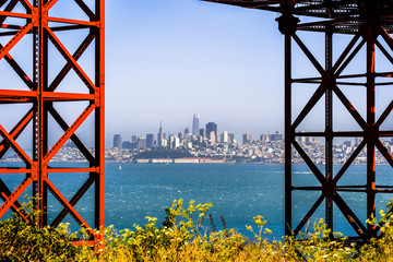 San Francisco's skyline visible between two of the pylons of the Golden Gate Bridge, California