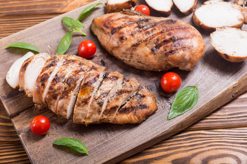 Grilled chicken breast ( fillet ) with basil and tomatoes