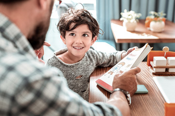 Teaching letters. Dark-haired funny boy listening attentively to his private tutor teaching him...