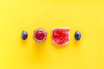 Sweet breakfast. Toast with plum jam on yellow background top view copy space