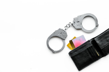 Arrest of cybercriminals, hackers concept. Handcuff near bank card on white background top view...