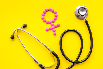 Female diseases concept. Stethoscope near female sign on yellow background top view