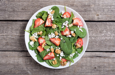 Strawberry salad with spinach , cheese and walnut . Healthy food