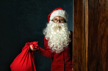 a boy dressed as Santa Claus on a dark background . Merry Christmas