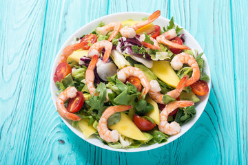 Mix of salad with shrimps , avocado and cherry tomatoes . Healthy food background
