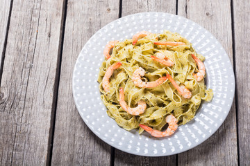 Pasta tagliatelle with sauce pesto and shrimps . Italian food background