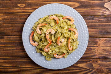 Pasta tagliatelle with sauce pesto and shrimps . Italian food background