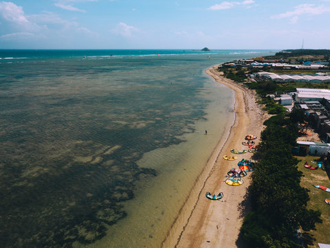 Kiteboarding, kite surf. Extreme sport kitesurfing in tropical blue ocean, clear beach. Aerial views, top view of kitesurfing on the waves of the beautiful sea in Vietnam. Kite surfer rides the waves