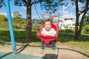 公園のブランコで遊ぶ子供