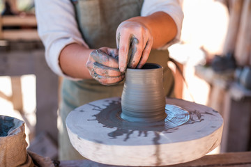 Potter is creating earthenware on potter's wheel.
