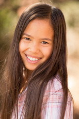 Portrait of a young asian girl smiling outside.