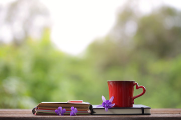 Red mug and notebooks with flower