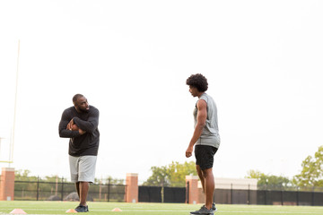 American Football coach training a young athlete.