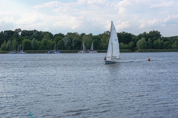 Sailing boat on a calm lake with reflection in the water. Serene scene landscape. Horizontal...
