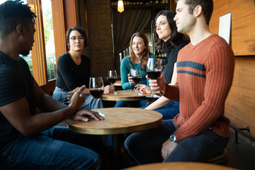Friends drinking wine together in restaurant during happy hour