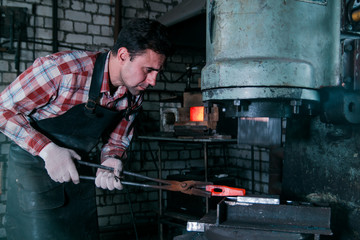 Workspace of blacksmith. Blacksmith working with red hot metal in a forge