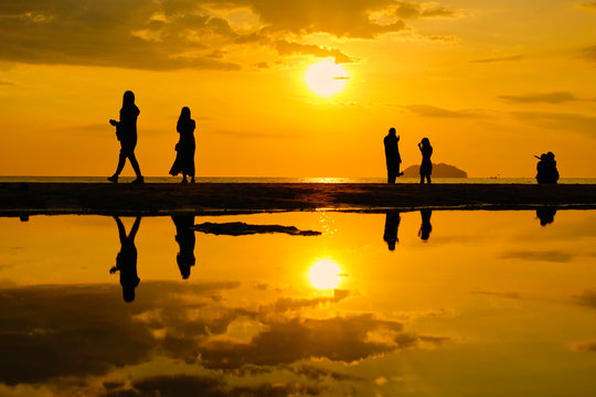Tourist visiting Tanjung Aru beach during sunset in Kota Kinabalu, Sabah, Malaysia.