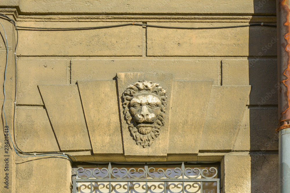 Poster window with stucco molding with lion head ornament above