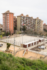 Fototapeta na wymiar Residential Area in Barcelona with a Playground. Cloudy Day.