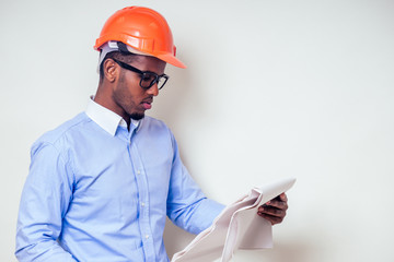 architect designer black man African American holding paper drawing template.happy african builder painting house,businessman wears a helmet hard hat.young guy is painting sketch construction plan