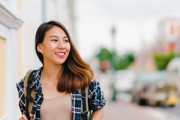 Fototapeta premium Traveler backpacker asian woman travel in Bangkok, Thailand. Happy young female spending holiday trip at amazing landmark and enjoy her journey in traditional city.