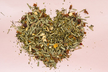 herbal tea, laid out in the shape of the heart, on a light background