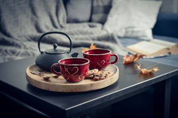Two cups of tea on a serving tray on coffee table.