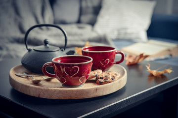 Two cups of tea on a serving tray on coffee table.