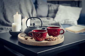 Two cups of tea on a serving tray on coffee table.