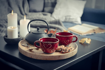 Two cups of tea on a serving tray on coffee table.