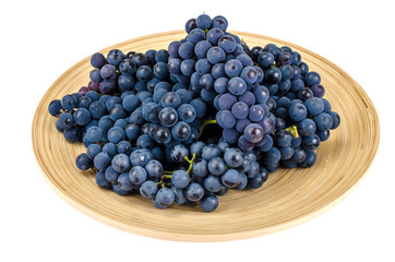 Wooden dish with black grapes